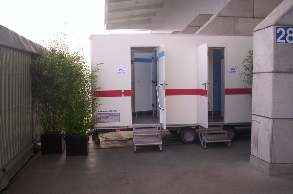 Zwei mobile Toilettenkabinen mit offenen Türen und roten Streifen auf weißem Grund